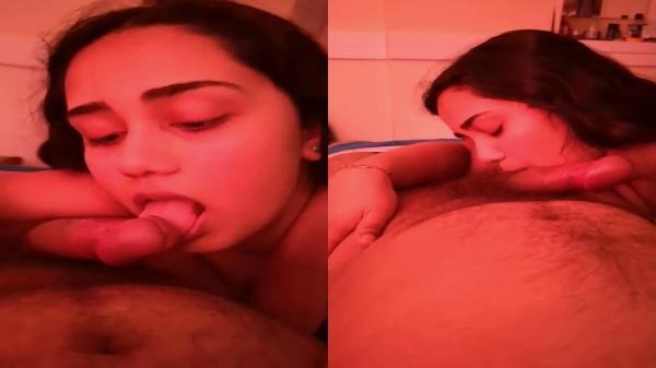 একটি লাল আলোয় আলোকিত কক্ষে এক দেশি তরুণী তার প্রেমিকের লিঙ্গ চুষছে
